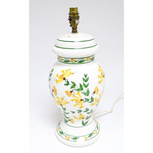 1676 - A late 20thC ceramic table lamp the white ground decorated with yellow and green floral decoration. ... 