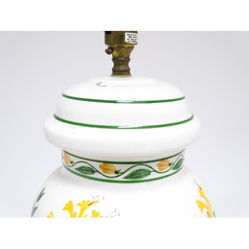 1676 - A late 20thC ceramic table lamp the white ground decorated with yellow and green floral decoration. ... 