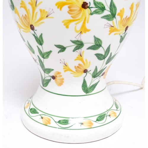 1676 - A late 20thC ceramic table lamp the white ground decorated with yellow and green floral decoration. ... 