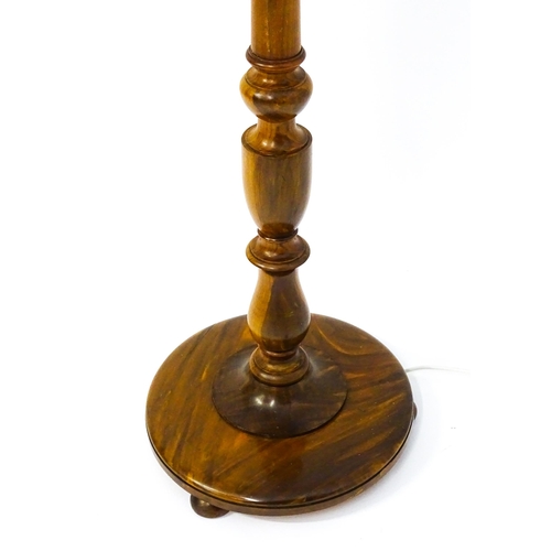 1683 - A turned wooden standard lamp raised on squat bun feet. Approx. 62