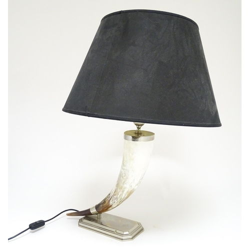 1694 - A 20thC table lamp the body of horn form, mounted on a weight silver plate base. Approx. 29