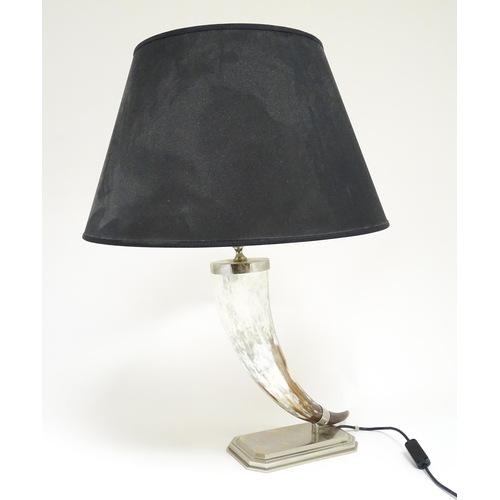 1694 - A 20thC table lamp the body of horn form, mounted on a weight silver plate base. Approx. 29