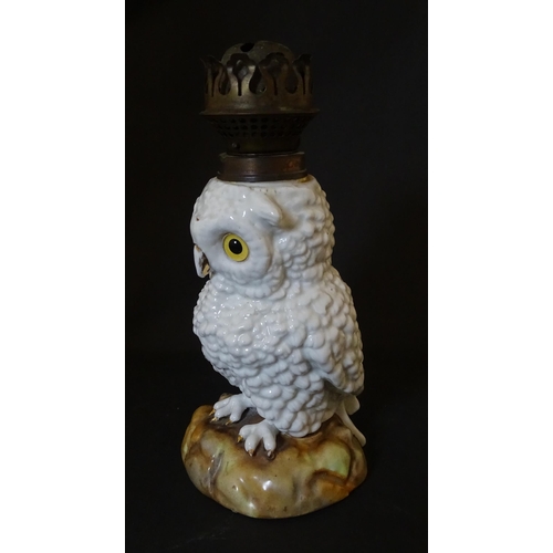 1697 - A novelty oil lamp the ceramic base formed as an owl with glass eyes. Marked under. Approx. 14 1/2