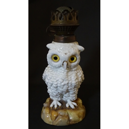 1697 - A novelty oil lamp the ceramic base formed as an owl with glass eyes. Marked under. Approx. 14 1/2