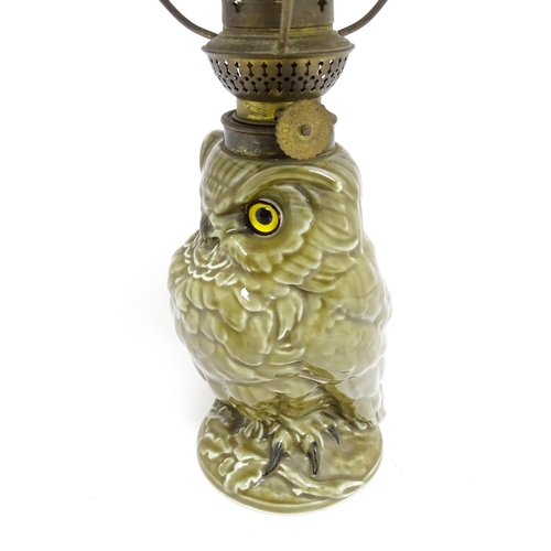 1698 - A novelty oil lamp the ceramic base formed as an owl with glass eyes. Marked under William Whiteley.... 