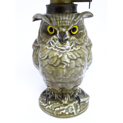 1698 - A novelty oil lamp the ceramic base formed as an owl with glass eyes. Marked under William Whiteley.... 