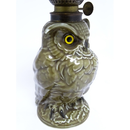 1698 - A novelty oil lamp the ceramic base formed as an owl with glass eyes. Marked under William Whiteley.... 