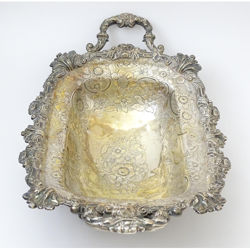 630 - A large George III silver twin handled dish with floral and C scroll decoration and raised on four l... 