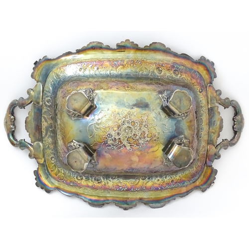 630 - A large George III silver twin handled dish with floral and C scroll decoration and raised on four l... 