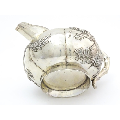 638 - Chinese Export Silver: A late 19th / early 20thC white metal three piece tea set with relief dragon ... 