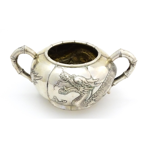 638 - Chinese Export Silver: A late 19th / early 20thC white metal three piece tea set with relief dragon ... 