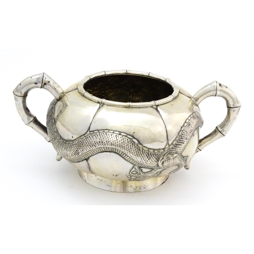 638 - Chinese Export Silver: A late 19th / early 20thC white metal three piece tea set with relief dragon ... 