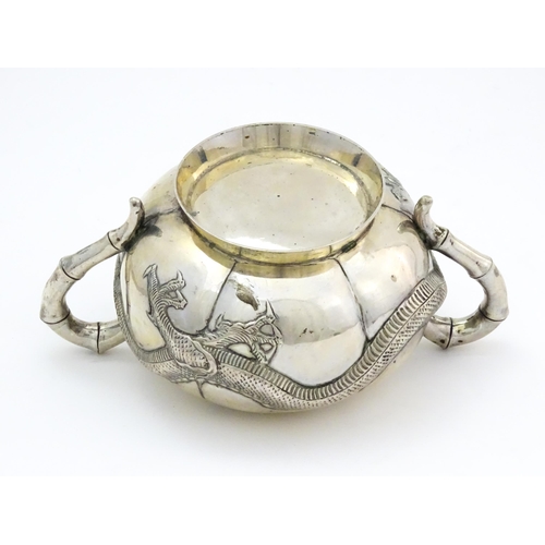 638 - Chinese Export Silver: A late 19th / early 20thC white metal three piece tea set with relief dragon ... 