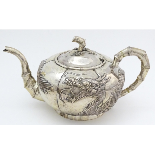 638 - Chinese Export Silver: A late 19th / early 20thC white metal three piece tea set with relief dragon ... 