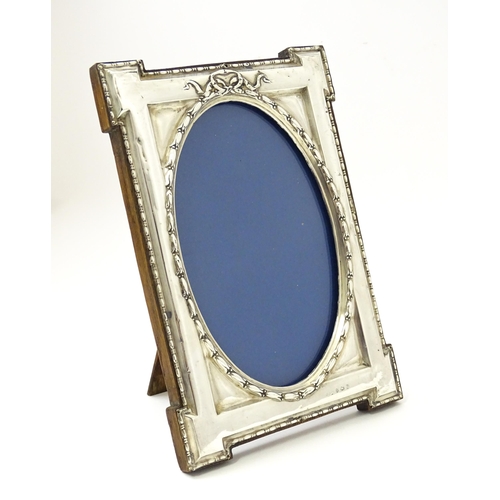 648 - An easel back photograph frame with silver surround hallmarked Birmingham 1914, maker W. I Broadway ... 