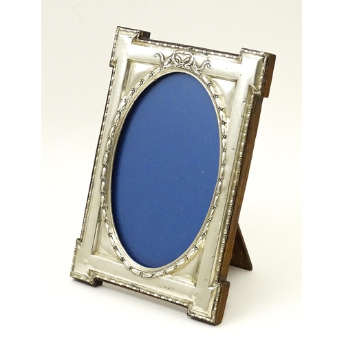 648 - An easel back photograph frame with silver surround hallmarked Birmingham 1914, maker W. I Broadway ... 