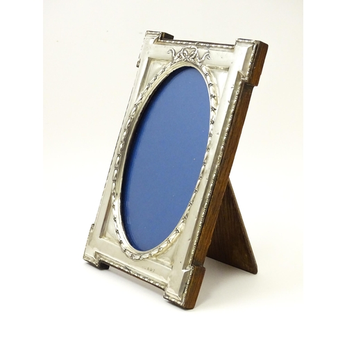 648 - An easel back photograph frame with silver surround hallmarked Birmingham 1914, maker W. I Broadway ... 