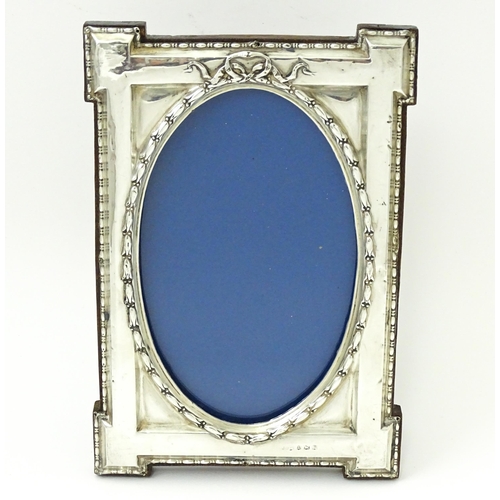 648 - An easel back photograph frame with silver surround hallmarked Birmingham 1914, maker W. I Broadway ... 