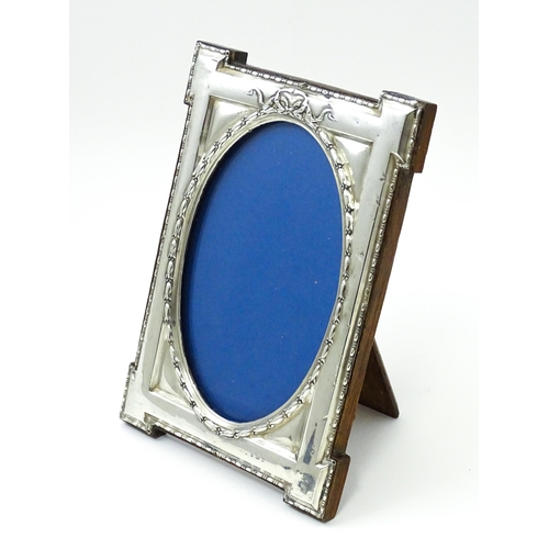 648 - An easel back photograph frame with silver surround hallmarked Birmingham 1914, maker W. I Broadway ... 