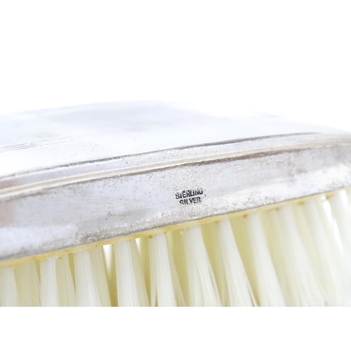 653 - A cased silver brush with engine turned decoration and a silver mounted comb, hallmarked Birmingham ... 