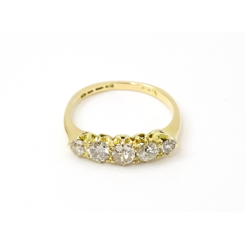 775 - An 18ct gold ring set with five old cut diamonds. Ring size approx. O