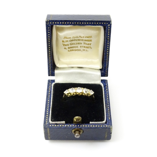 775 - An 18ct gold ring set with five old cut diamonds. Ring size approx. O