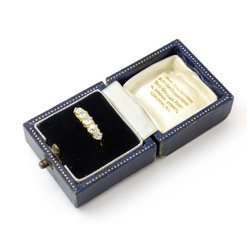 775 - An 18ct gold ring set with five old cut diamonds. Ring size approx. O