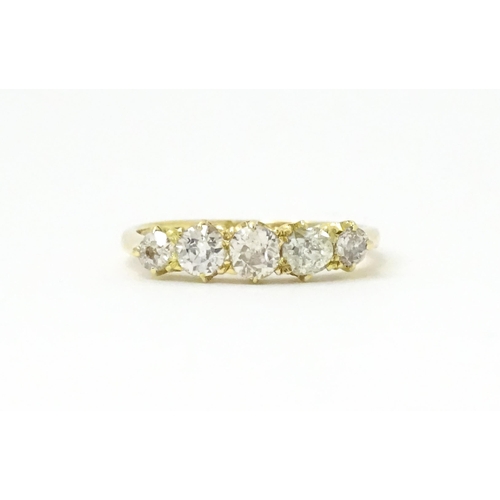 775 - An 18ct gold ring set with five old cut diamonds. Ring size approx. O