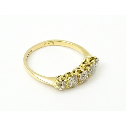 775 - An 18ct gold ring set with five old cut diamonds. Ring size approx. O