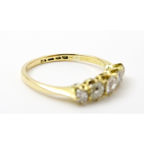 775 - An 18ct gold ring set with five old cut diamonds. Ring size approx. O