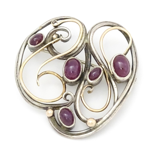 777 - A white metal brooch with yellow metal detail and set with five ruby cabochon. Approx.  1 1/2