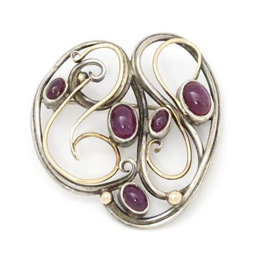 777 - A white metal brooch with yellow metal detail and set with five ruby cabochon. Approx.  1 1/2