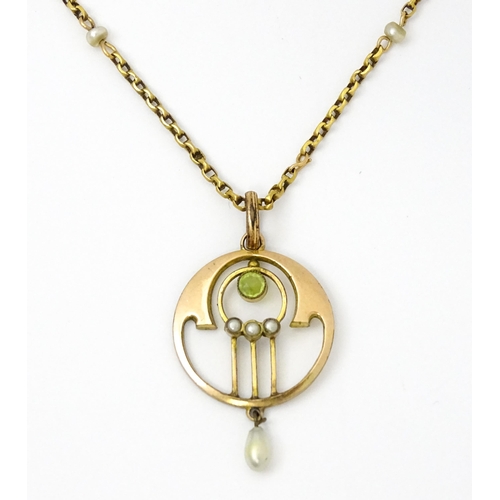 779 - An Art Nouveau yellow metal pendant set with peridot and pearl, with a yellow metal chain set with p... 