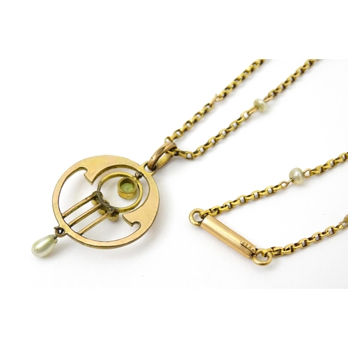 779 - An Art Nouveau yellow metal pendant set with peridot and pearl, with a yellow metal chain set with p... 