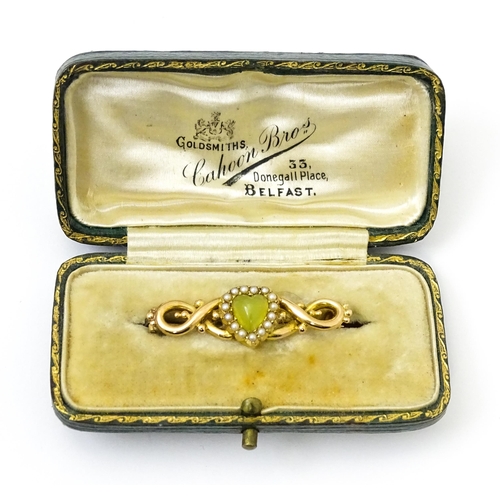 782 - A late 19thC / early 20thC yellow metal brooch set with central heart cabochon bordered by seed pear... 