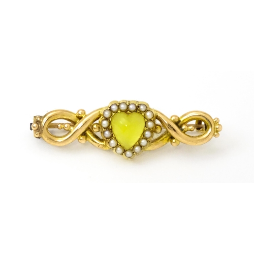 782 - A late 19thC / early 20thC yellow metal brooch set with central heart cabochon bordered by seed pear... 