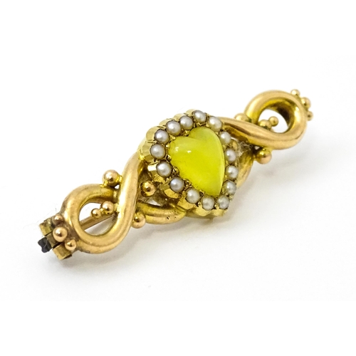 782 - A late 19thC / early 20thC yellow metal brooch set with central heart cabochon bordered by seed pear... 