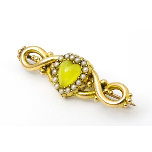 782 - A late 19thC / early 20thC yellow metal brooch set with central heart cabochon bordered by seed pear... 