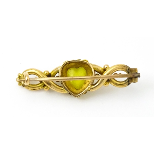 782 - A late 19thC / early 20thC yellow metal brooch set with central heart cabochon bordered by seed pear... 