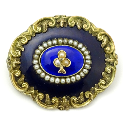 784 - A 19thC memorial / mourning brooch with blue enamel detail and central motif set with seed pearls an... 