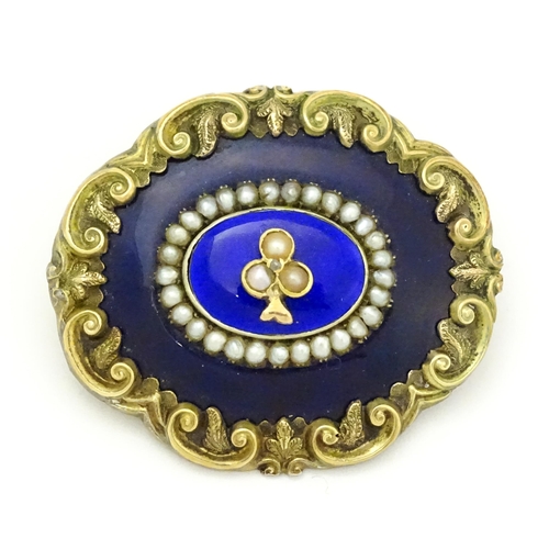 784 - A 19thC memorial / mourning brooch with blue enamel detail and central motif set with seed pearls an... 