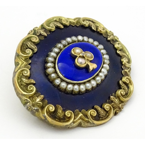 784 - A 19thC memorial / mourning brooch with blue enamel detail and central motif set with seed pearls an... 