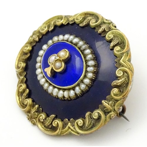 784 - A 19thC memorial / mourning brooch with blue enamel detail and central motif set with seed pearls an... 