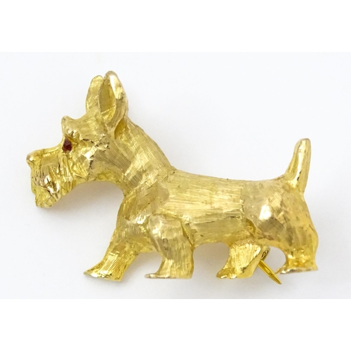 785 - A 9ct gold dog brooch formed as a Highland terrier with red stone eye. Approx 1 1/4