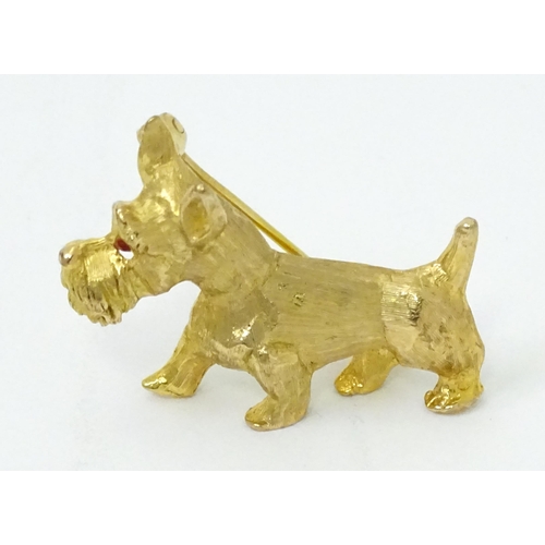 785 - A 9ct gold dog brooch formed as a Highland terrier with red stone eye. Approx 1 1/4