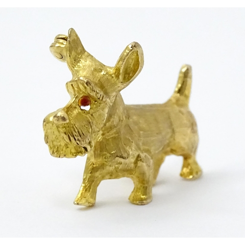 785 - A 9ct gold dog brooch formed as a Highland terrier with red stone eye. Approx 1 1/4