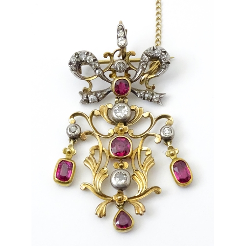 787 - A Belle Epoque pendant set with scrolling detail set with rubies and diamonds surmounted by a bow se... 