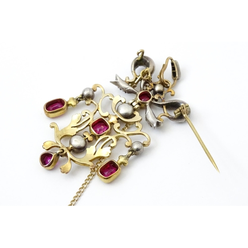 787 - A Belle Epoque pendant set with scrolling detail set with rubies and diamonds surmounted by a bow se... 