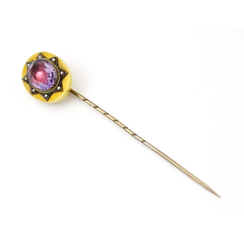 795 - A late 19thC / early 20thC yellow metal stick pin set with Amethyst bordered by seed pearls. Approx ... 