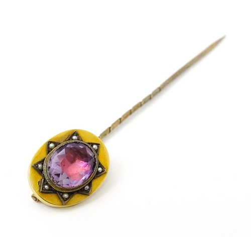 795 - A late 19thC / early 20thC yellow metal stick pin set with Amethyst bordered by seed pearls. Approx ... 